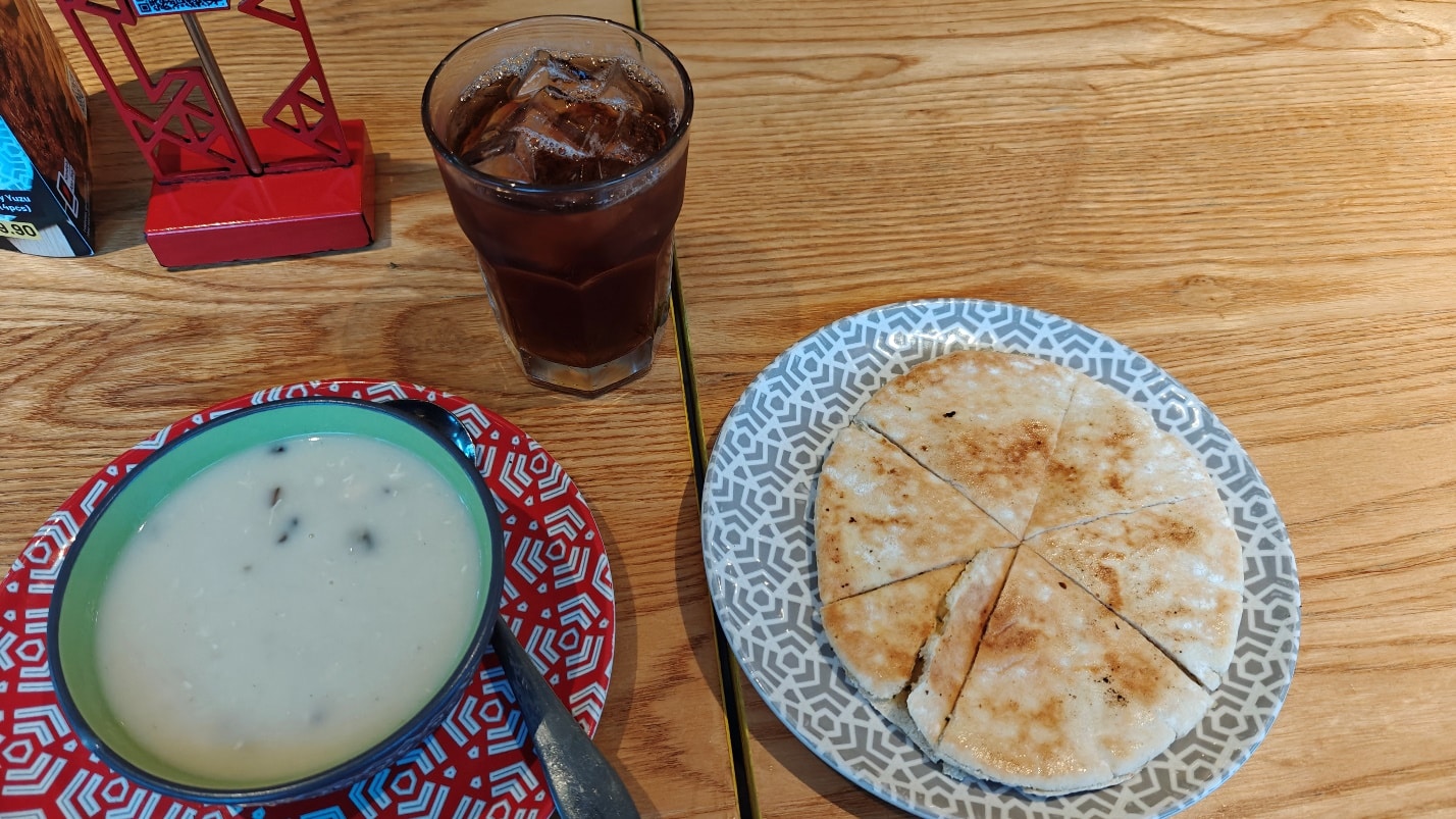 Mushroom soup, garlic cheesy pita bread, and drink at Nando’s