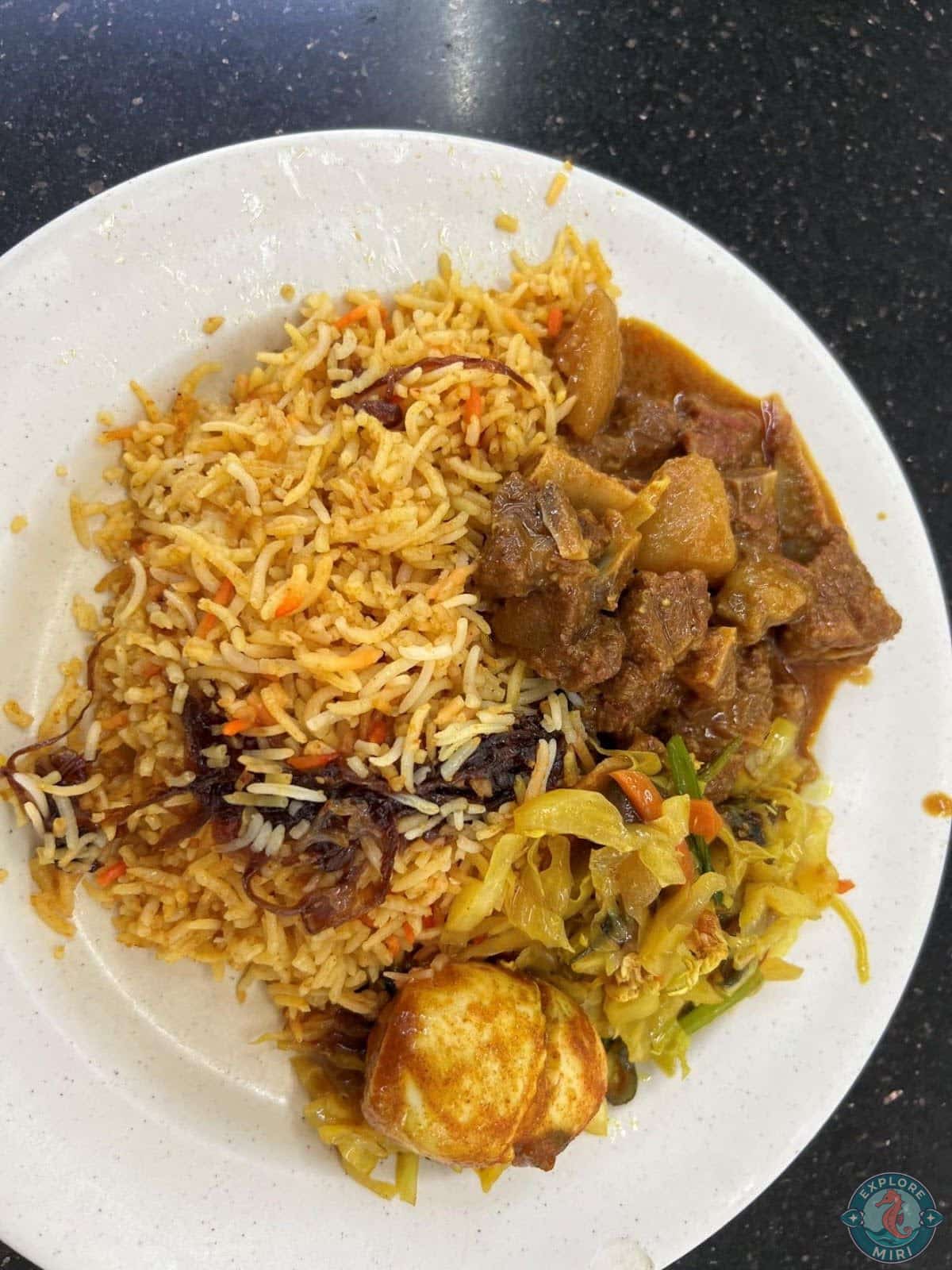 briyani rice with a side of lamb curry and a boiled egg