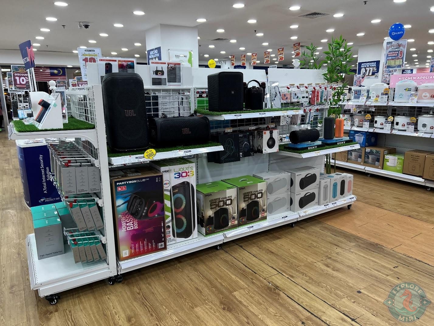 rack display of speakers from various brands like JBL and Waves