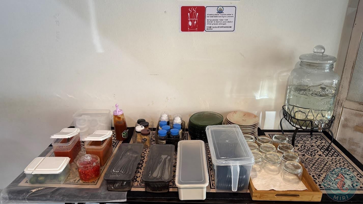 table setup with spoons, forks in boxes and trays of glasses ad pickled sides