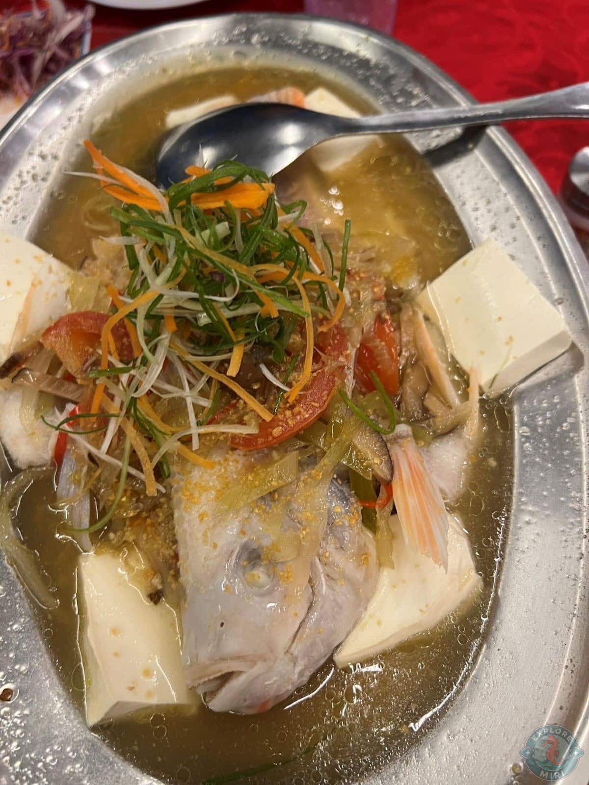 steamed fish freshly served with silken tofu and garnished with fresh veggies and garlic