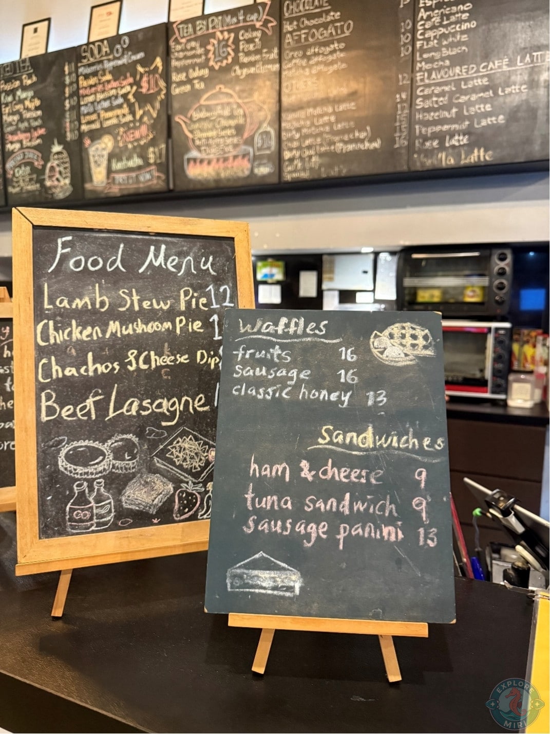 chalkboard menu on the counter with meat pie, waffles and sandwich menu