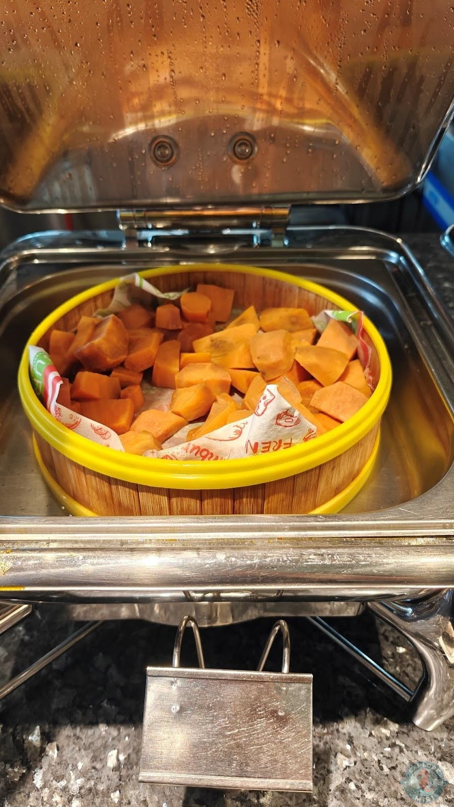 huge steaming basket full of some root vegetables, like sweet potato or pumpkin