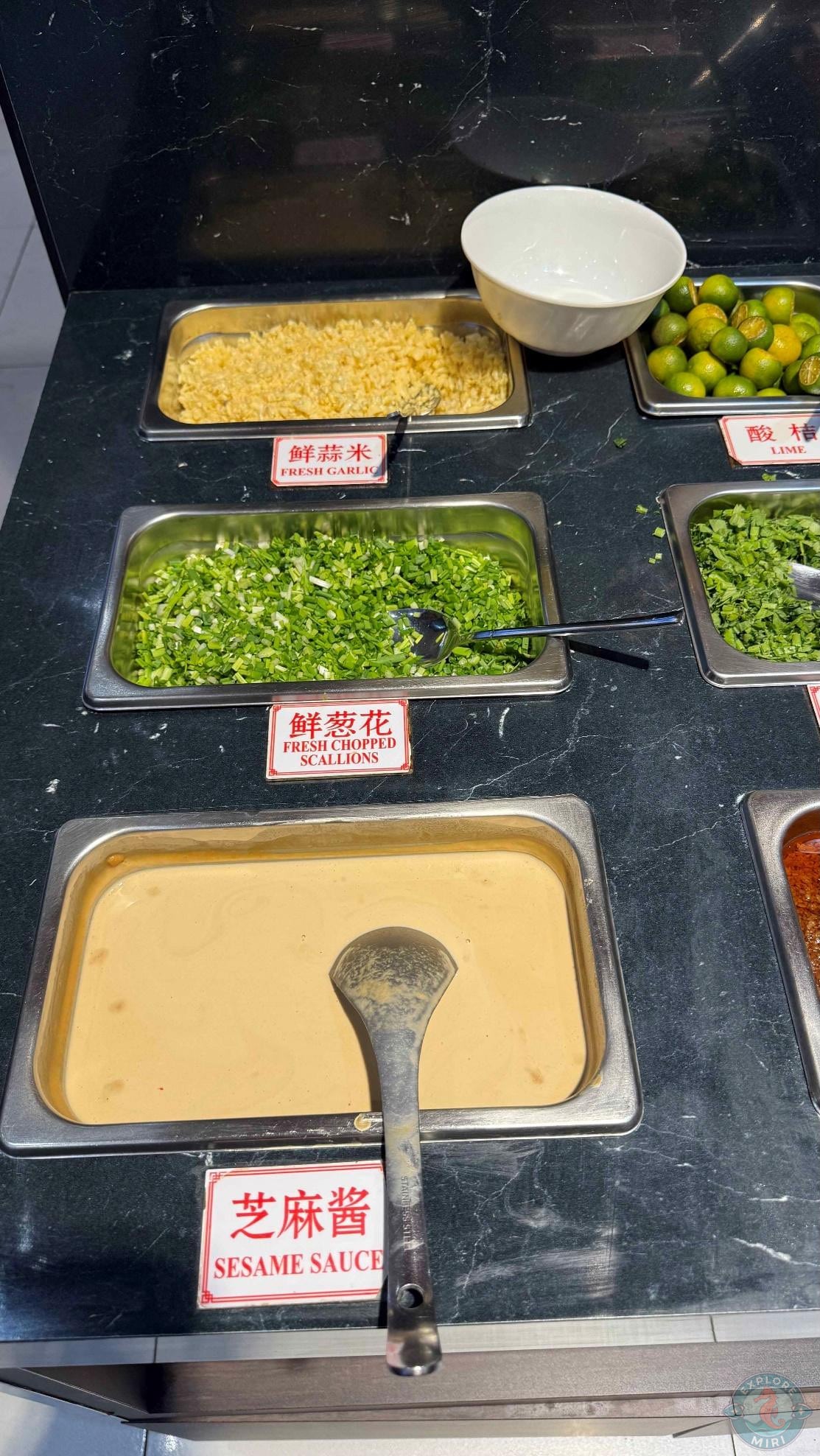 toppings including fresh garlic, lime, scallions, sesame sauce and more